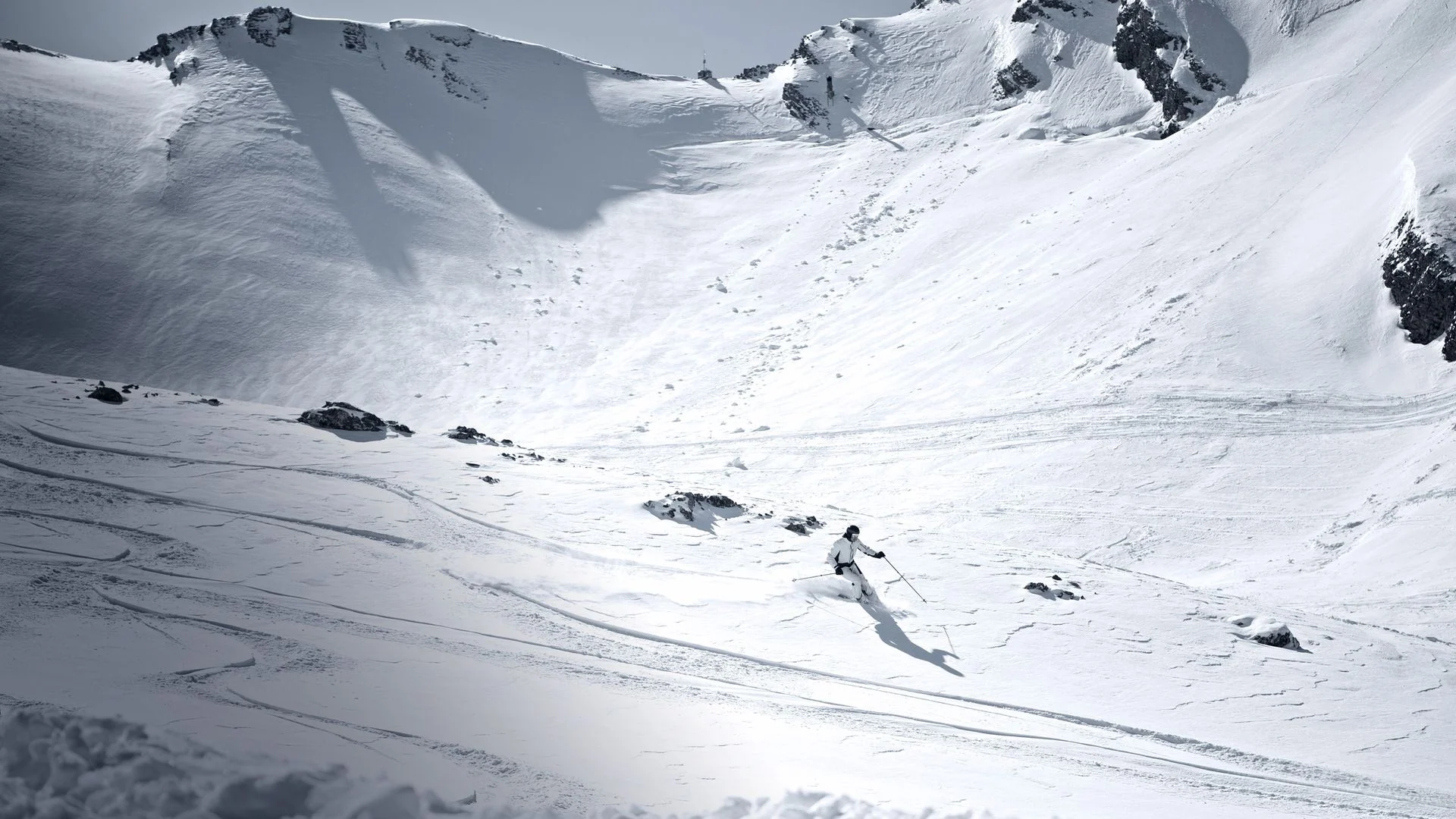 Skieur traçant une courbe sur un sommet alpin