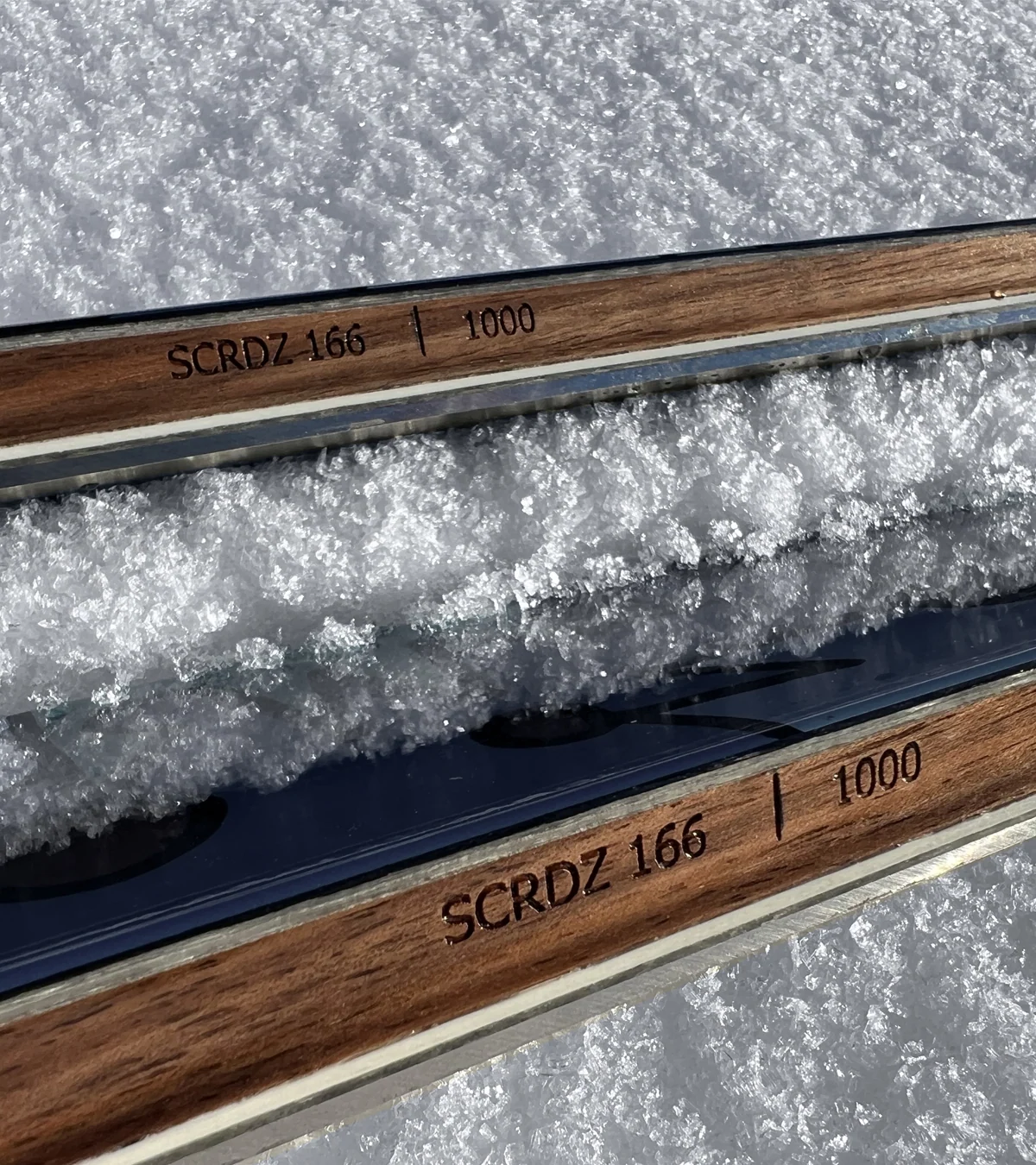 Initiales gravées sur les chants de skis Dénériaz